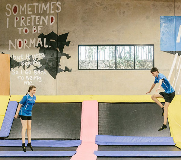 Two teens enjoying therapeutic fun at a trampoline park. Discover OT resources for active and engaging therapies. #OTresources